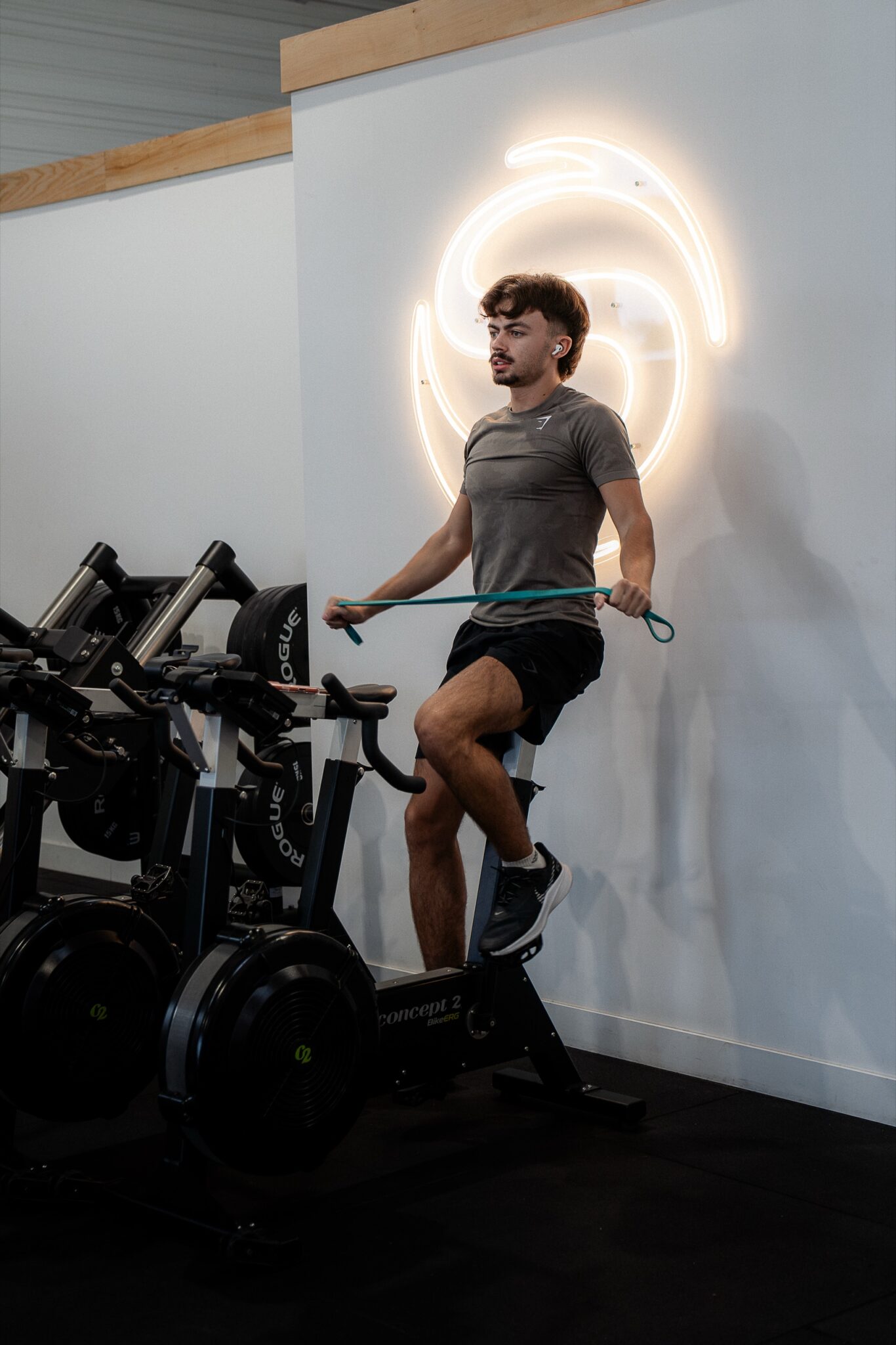 Un adhérent à l’effort devant le logo lumineux de La Sphère, près des BikeErg